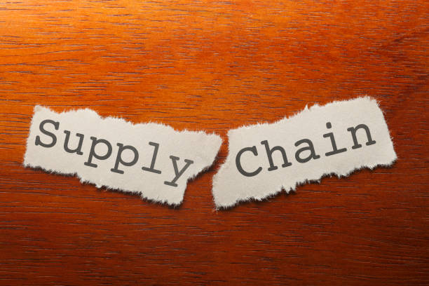 Broken Supply Chain "Supply Chain" printed on a piece of paper that is torn into two pieces resting on a wood desk. inconvenience photos stock pictures, royalty-free photos & images