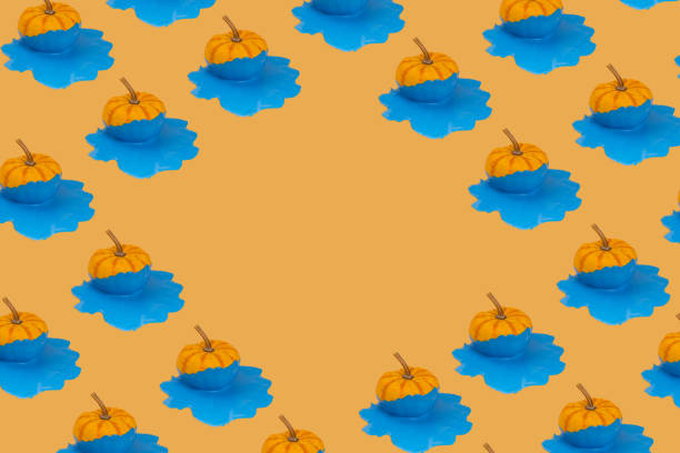 Trendy autumn pattern fresh pumpkin with dripping and melting paint on orange background with copy space. Minimal Autumn, Halloween or Thanksgiving concept background.