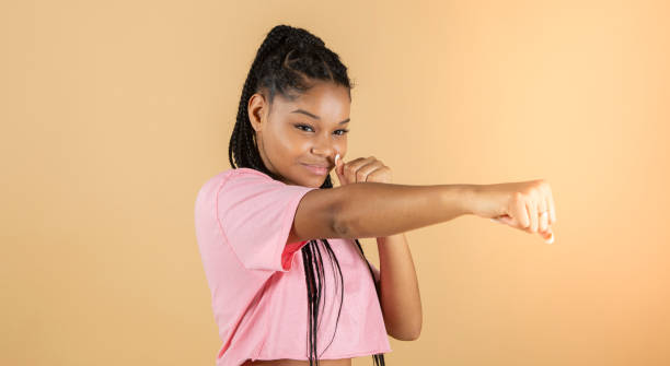 istock Image of a young African boxer throws punch, strong woman, yellow background 1341709021