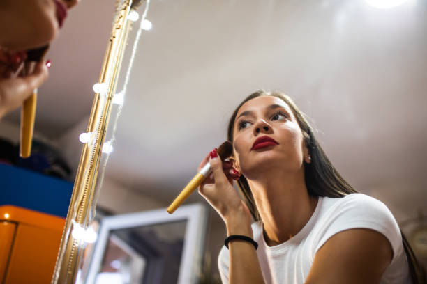 istock A beautiful young woman doing makeup in front of a mirror 1341711433