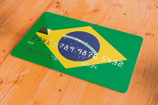 Plastic credit or bank debit card with country flag of Brazil national banking system isolated on wooden table close up concept 3d rendering image