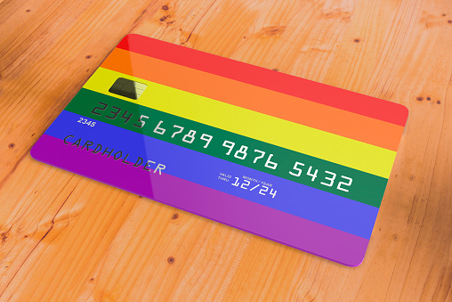 Plastic credit or bank debit card with flag of LGBT isolated on wooden table close up concept 3d rendering image