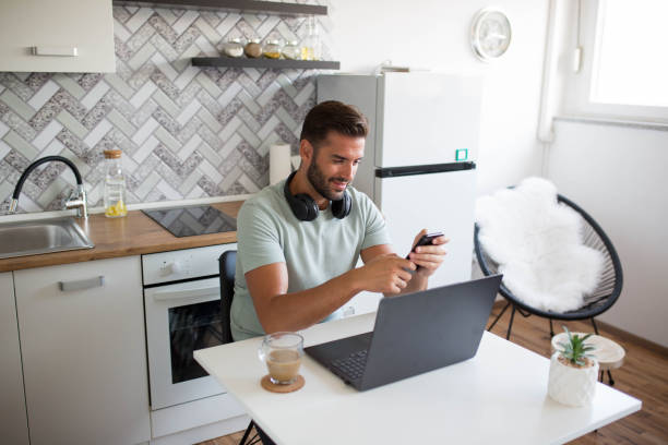 istock A handsome man works on a laptop at home with morning coffee 1341714780