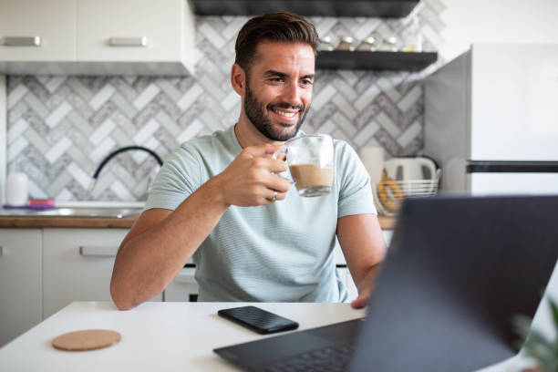 istock A handsome man works on a laptop at home with morning coffee 1341714800