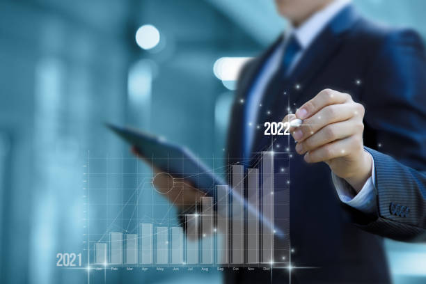 Businessman on the virtual screen at the end of the growth graph clicks to 2022. stock photo