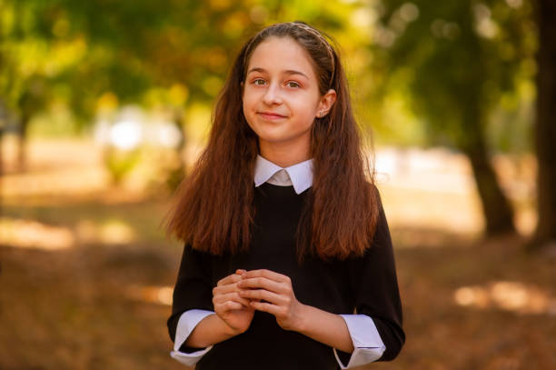 school concept. little girl 11 or 12 years old in a dress on the background of nature in autumn. - 12 13 years fotos imagens e fotografias de stock