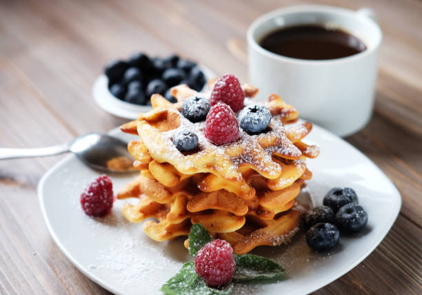 istock Waffles with berries on a white plate and coffee, close up 1341720410
