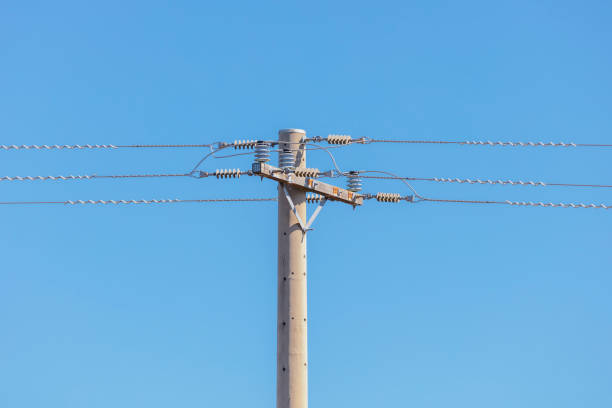 Photograph of a concrete telephone post and cables against a blue sky Photograph of a concrete telephone post and cables against a blue sky utility pole with power lines close up stock pictures, royalty-free photos & images