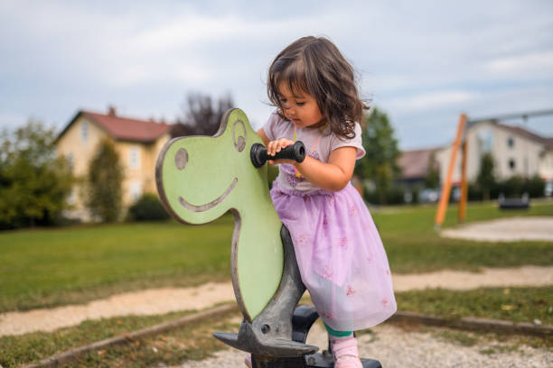 Shot of a young girl playing in public a playground in the park.