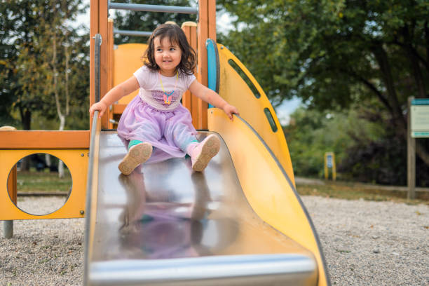 istock Young Girl About To Go Down the Slide 1341723362