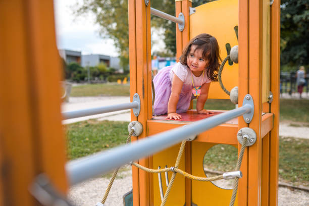 Shot of a young girl playing in public a playground in the park.
