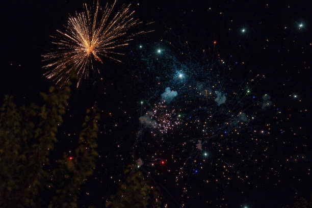 explosions de feux d’artifice colorés dans le ciel nocturne - firework explosive material photos et images de collection
