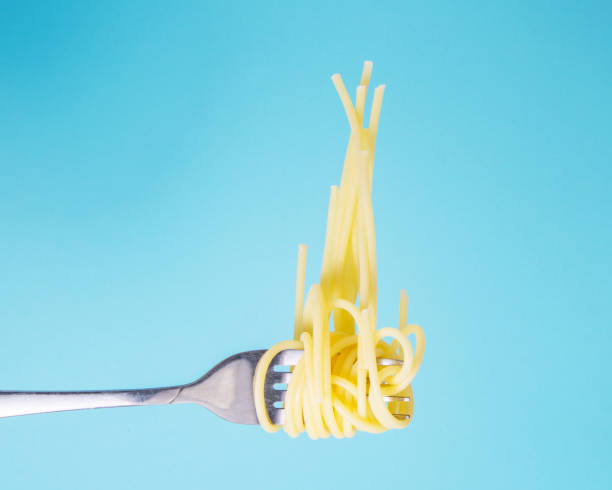istock Pasta on fork tasty on blue background with copy space 1341732547