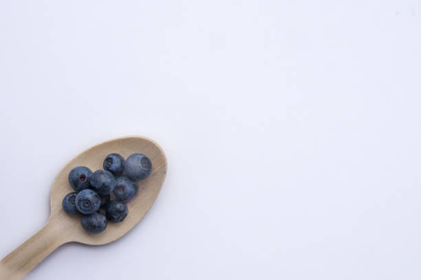 istock Recycled spoon and juicy, fresh blueberries on white background 1341732599