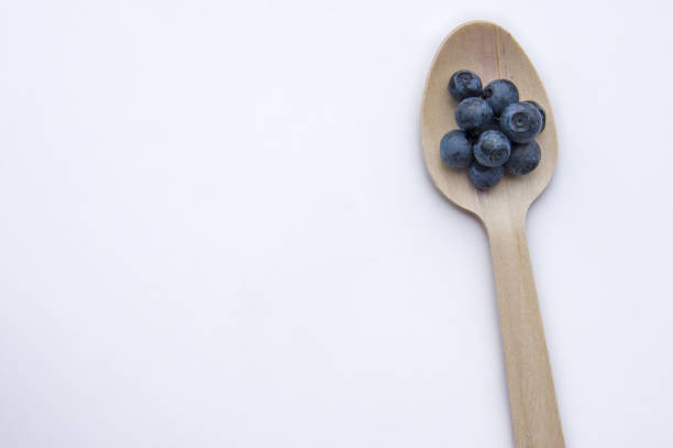 istock Recycled spoon and juicy, fresh blueberries on white background 1341732738