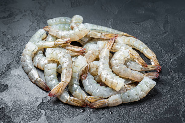 istock Fresh raw black shrimps prawns on a stone Board. Black background. Top view 1341733492