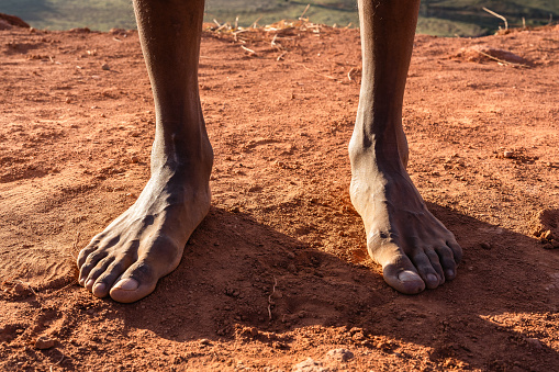 Bare feet a black man on the clay floor