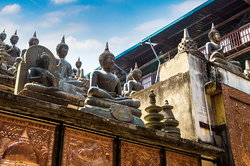Statues of the Buddha in Gangaramaya Buddhist Temple,  in Colombo in a sunny day, Sri Lanka