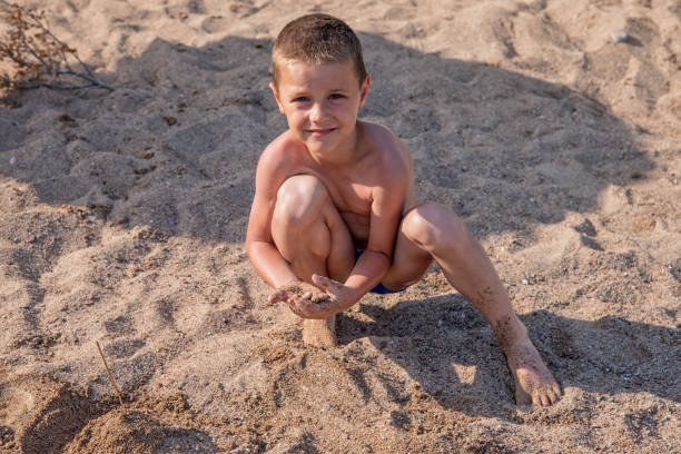 Boy sitting on the sand at the beach