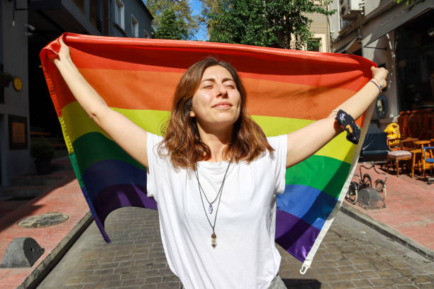 LGBT proud. Happy woman holding lgbt flag stock photo
