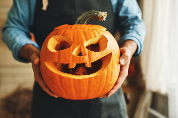 istock man in apron with Halloween pumpkin monster spooky jack-o-lanter 1341748061