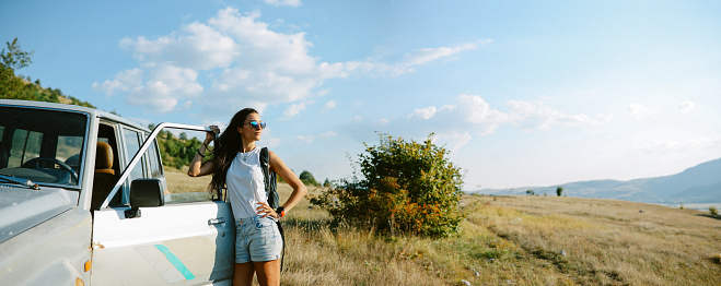 Young woman on a road trip in the beautiful nature, relaxing, using an all terrain vehicle for sightseeing.