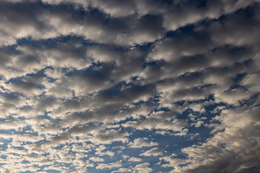 A panoramic view of scattered white clouds against a blue sky