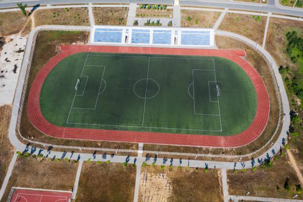 vista de drone de um campo de futebol vazio com arquibancadas e esteiras - school sport high up tall - fotografias e filmes do acervo