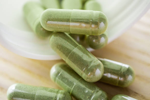 istock Herbal medicine capsules with bottle on wood table 1341759806