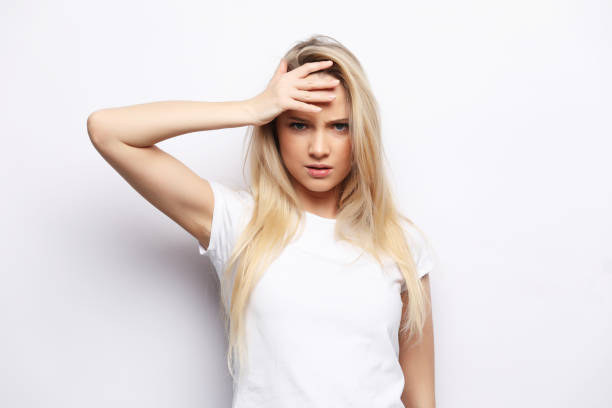 istock Young woman has headache, over white background 1341768368