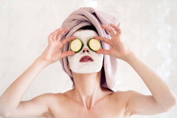 소녀는 얼굴에 하얀 점토 마스크를 적용합니다. - clear sky human skin towel spa treatment 뉴스 사진 이미지