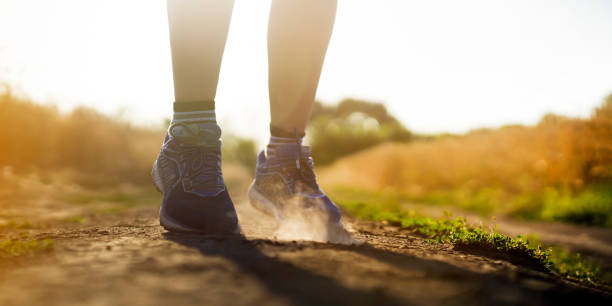 istock Female athletic legs and dust from the trail close up. 1341770708