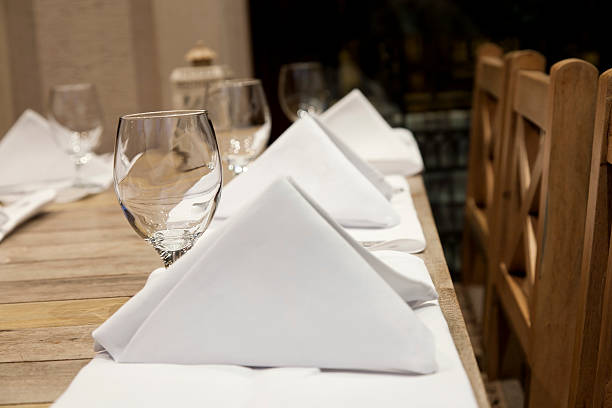 dining table with napkins and emty wine glasses stock photo