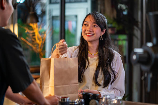 istock Asian man barista preparing take away order to customer. 1341772754