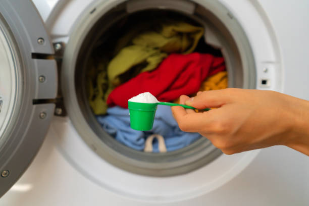 istock Female hand holds a cap with washing powder. 1341773911