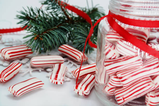hintergrund des weihnachtsthemas. weihnachten gestreifte süßigkeiten im glas und auf dem tisch. - peppermint candy stick striped stock-fotos und bilder