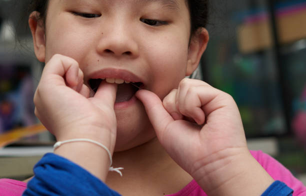 istock Asian girl flossing teeth to clean teeth after brushing 1341779850