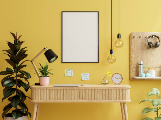 istock Mockup frame on work table in living room interior on empty yellow wall background. 1341782427