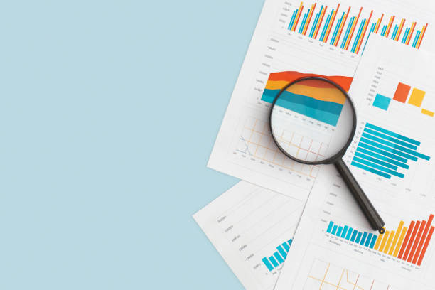 grafici aziendali, grafici e lente d'ingrandimento sul tavolo. sviluppo finanziario, conto bancario, statistica - rapporto foto e immagini stock