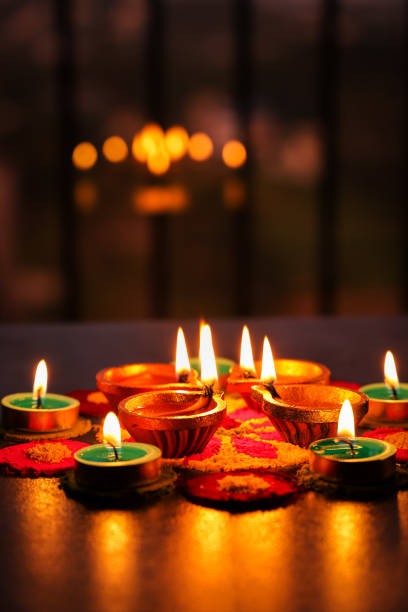 diwali feier indisches lichterfest diya öllampe und farben rangoli dekoration helle bunte blumen - diwali lights stock-fotos und bilder