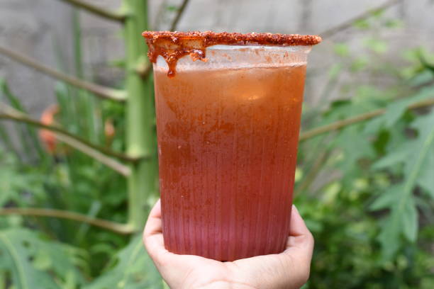 Holding a michelada in the middle of the vegetation Holding a michelada in the middle of the vegetation, beer vodka sauce stock pictures, royalty-free photos & images