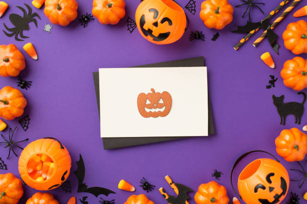 istock Top view photo of halloween decorations pumpkin baskets candy corn spiders web cat bats silhouettes straws black envelope and orange pumpkin silhouette on white card on isolated violet background 1341792742