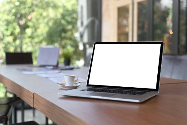 istock Computer laptop, coffee cup and documents on wooden table in meeting room. 1341794531