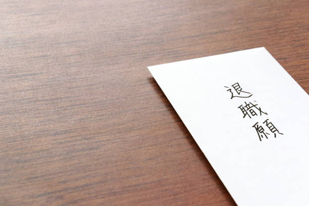 机の上の辞表。日本語で「辞表」と書かれた白い封筒。 - 退職 ストックフォトと画像