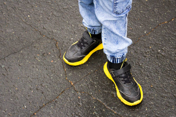 istock A child in black sneakers with a yellow sole 1341799134