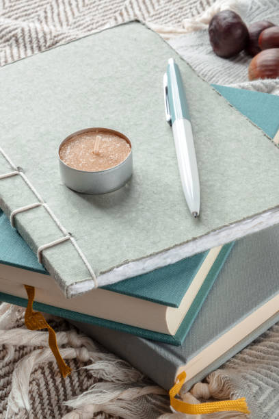 Hygge. A journal and a scented candle. Notebooks on a blanket