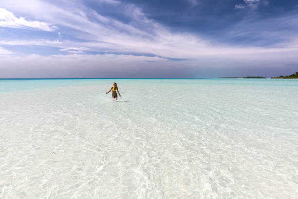 istock Young happy woman having fun while running through sea. 1341799207