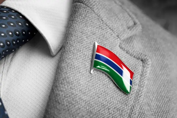 Metal badge with the flag of Gambia on a suit lapel.