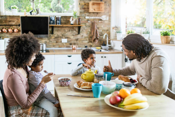 istock Happy black family talking while having breakfast in the morning. 1341800777