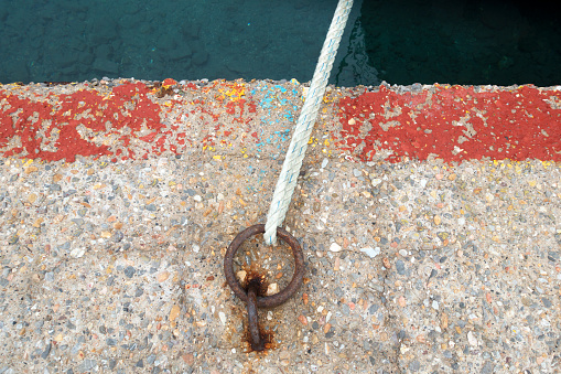 Stainless steel mooring equipment on the teak foredeck of the power boat.